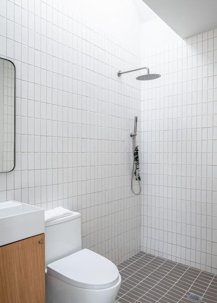 Full bathroom with vanity, a stall shower, and tile walls