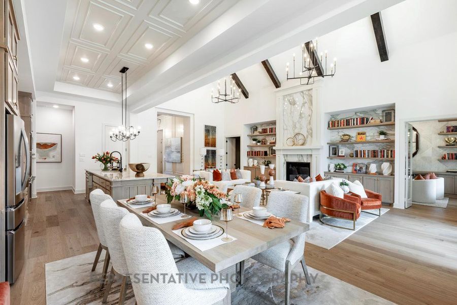 Dining space featuring a chandelier, recessed lighting, light wood-style flooring, a fireplace, and a towering ceiling Dining space featuring a chandelier, recessed lighting, light wood-style flooring, a fireplace, and a towering ceiling