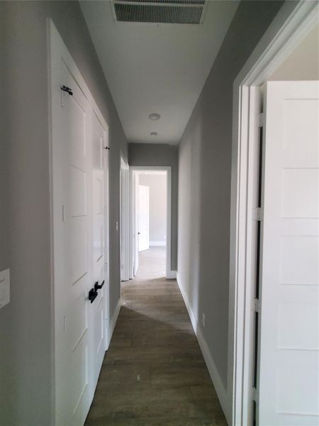 HALLWAY LEADING TO THE 3 SECONDARY BEDS WITH ONE BEING THE GUEST SUITE.