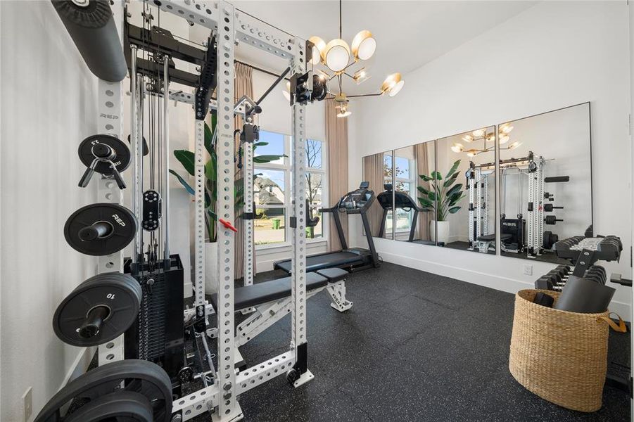 Gym with a notable chandelier