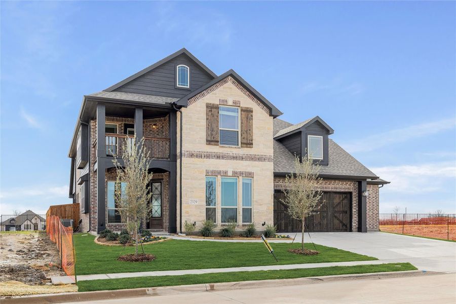 Two-story home with stone and brick exterior, second-floor balcony, and two-car garage Two-story home with stone and brick exterior, second-floor balcony, and two-car garage