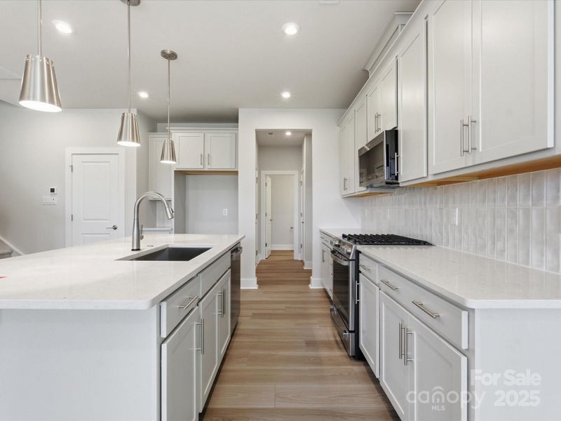 Quartz Countertops Paired With Glossy White Backsplash.