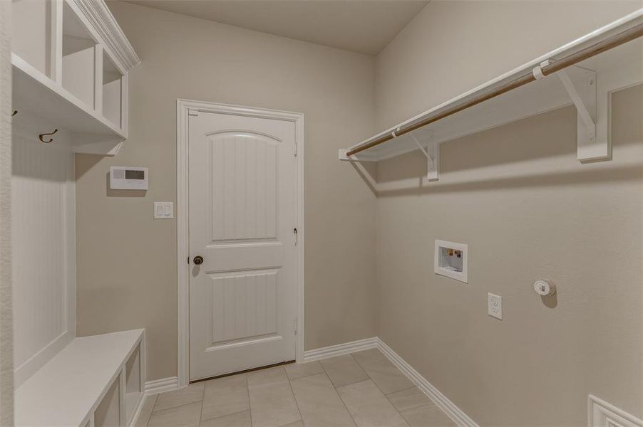Utility room featuring light-toned walls and tile flooring