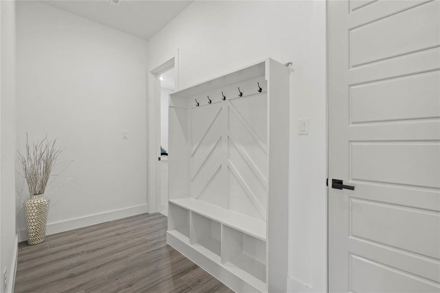 Mudroom with wood finished floors and baseboards