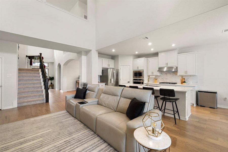 The living room sits at the center of the home with an open design that keeps conversations and movement effortless