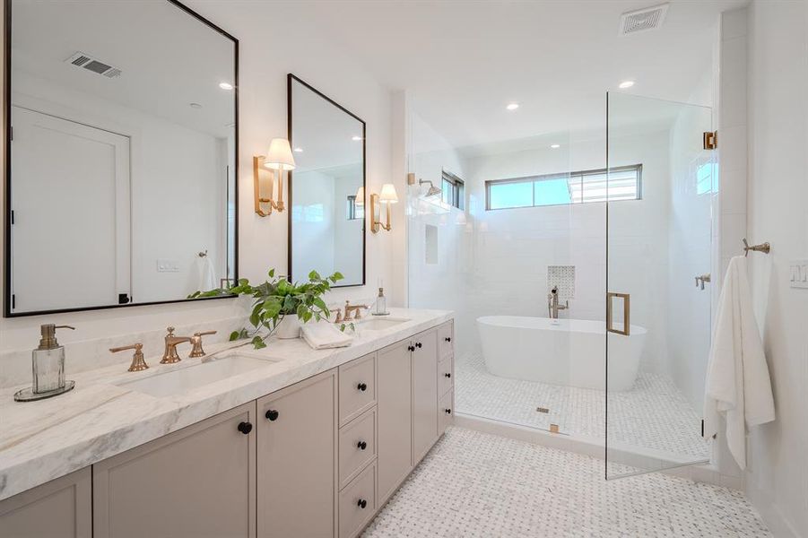 Full bath featuring double vanity, a shower stall, a freestanding bath, recessed lighting, and light tile patterned flooring