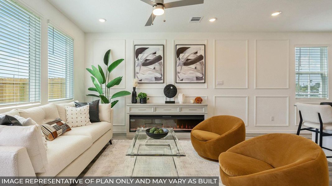 A refined living space features decorative wall molding, an elegant fireplace, and abundant natural light. A refined living space features decorative wall molding, an elegant fireplace, and abundant natural light.