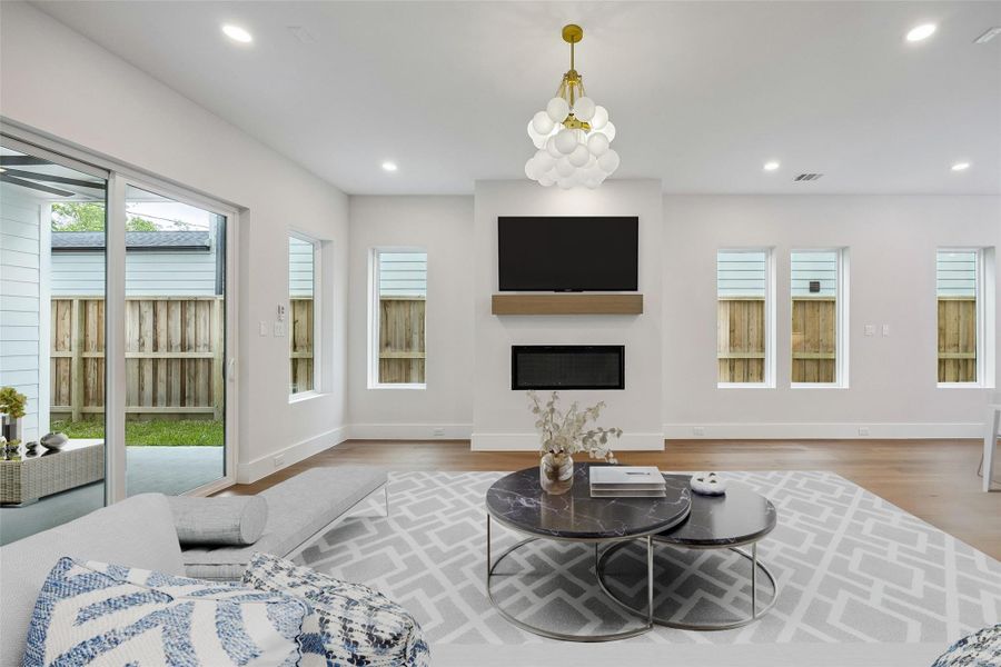 Positioned between the living and dining spaces, the fireplace creates a natural focal point within the first floor layout. The surrounding windows help frame the space and bring in soft natural light throughout the day. (digitally staged) Positioned between the living and dining spaces, the fireplace creates a natural focal point within the first floor layout. The surrounding windows help frame the space and bring in soft natural light throughout the day. (digitally staged)