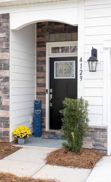 Front porch accented with stone and craftsman style front door