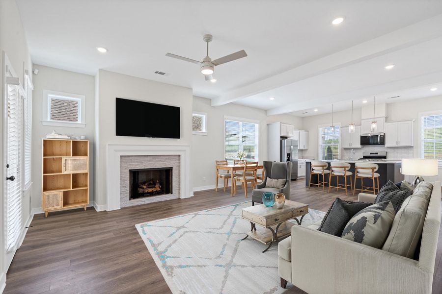 Living area featuring ceiling fan, dark wood finished floors, beam ceiling, a fireplace, and recessed lighting Living area featuring ceiling fan, dark wood finished floors, beam ceiling, a fireplace, and recessed lighting