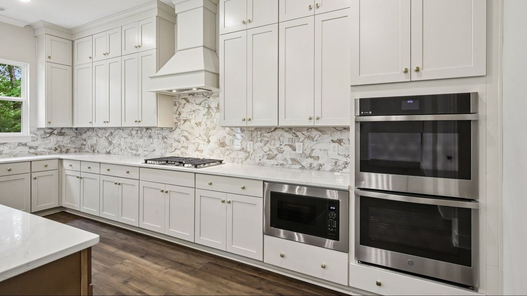 Kitchen with quartz countertops and tile backsplash Kitchen with quartz countertops and tile backsplash