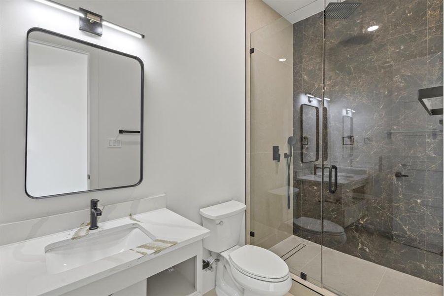 Bathroom with vanity, a stall shower, and toilet