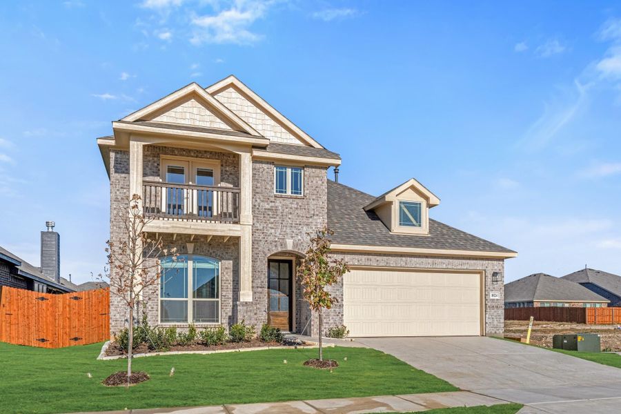 Two-story brick home with second-floor balcony, two-car garage, and manicured front lawn Two-story brick home with second-floor balcony, two-car garage, and manicured front lawn