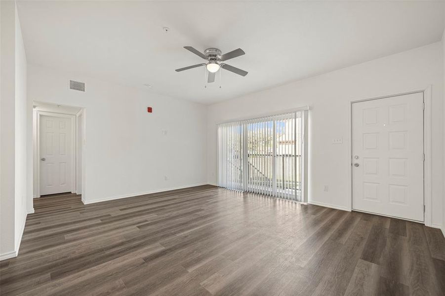 Living room featuring ceiling fan and dark wood-type flooring