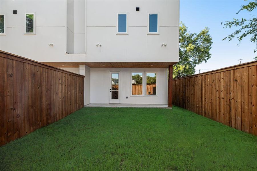 Rear view of house with a patio, stucco siding, and a fenced backyard Rear view of house with a patio, stucco siding, and a fenced backyard