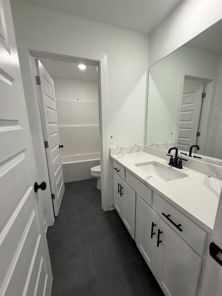 Bathroom with vanity and dark tile patterned flooring