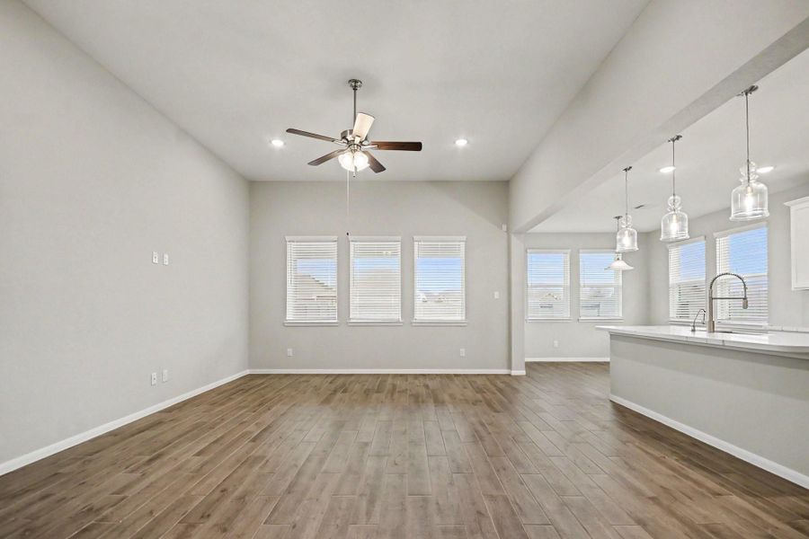 Abundant natural light from large windows, and a modern kitchen featuring stylish pendant lighting and a sleek island.
