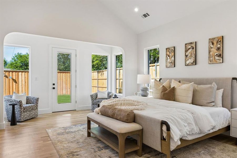 Bedroom featuring light wood-type flooring, vaulted ceiling, access to outside, and recessed lighting