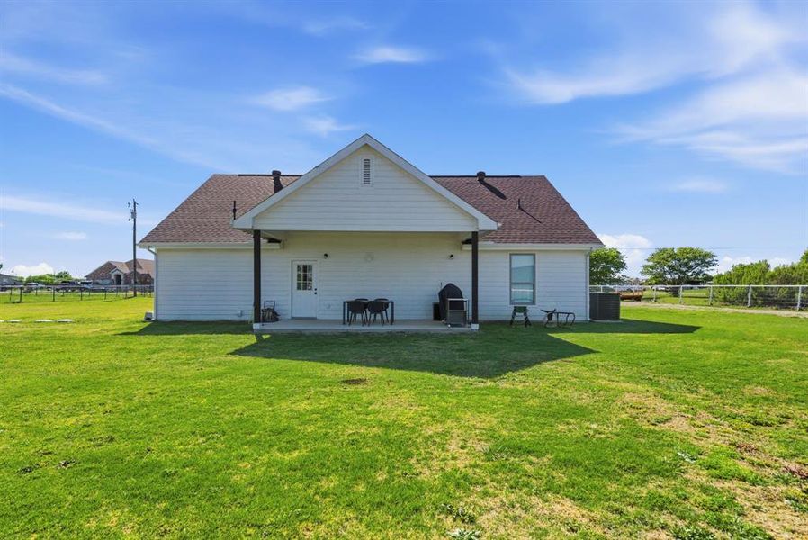 Rear view of property with a patio, a fenced backyard, and roof with shingles Rear view of property with a patio, a fenced backyard, and roof with shingles