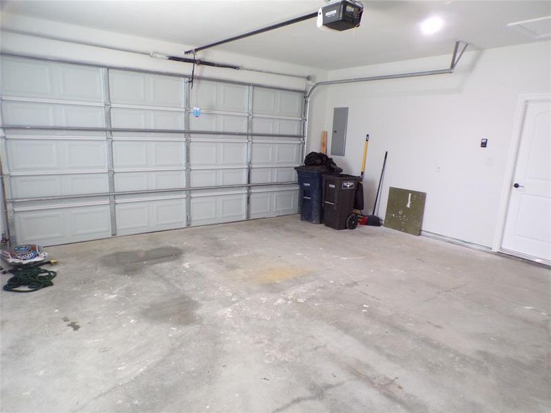 Garage with electric panel and a garage door opener