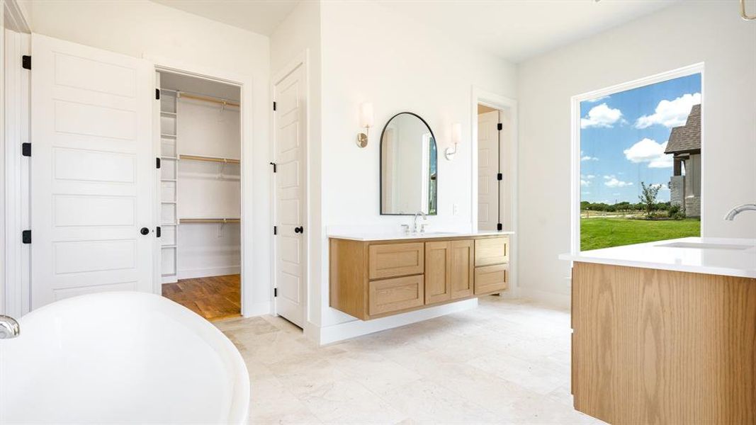 Bathroom featuring a washtub, vanity, and tile floors