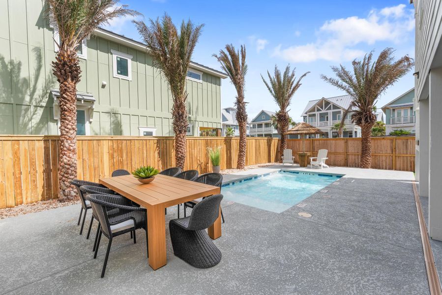 View of swimming pool featuring a patio area, a fenced backyard, outdoor dining space, and a residential view View of swimming pool featuring a patio area, a fenced backyard, outdoor dining space, and a residential view