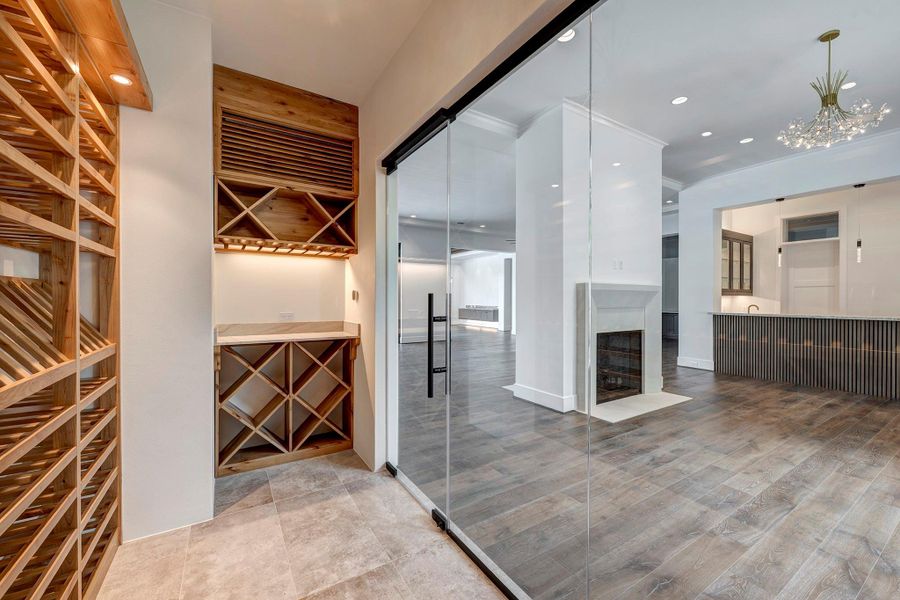 This impressive, climate-controlled wine room features elegant glass-front doors and rich wood bottle storage, offering ample space to showcase and preserve your finest vintages in sophisticated style.