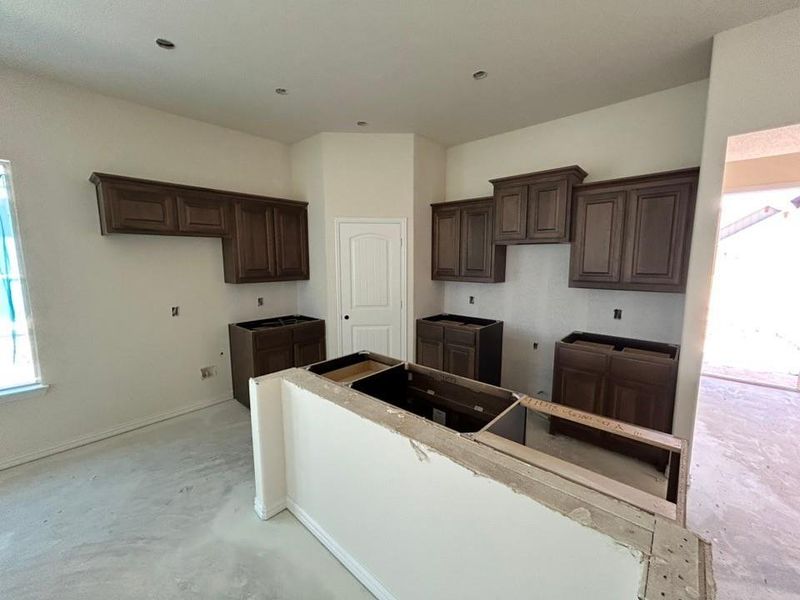 Kitchen featuring dark brown cabinetry and baseboards