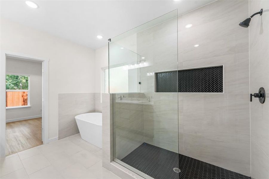 Modern bathroom featuring a frameless glass shower enclosure and a freestanding soaking tub Modern bathroom featuring a frameless glass shower enclosure and a freestanding soaking tub