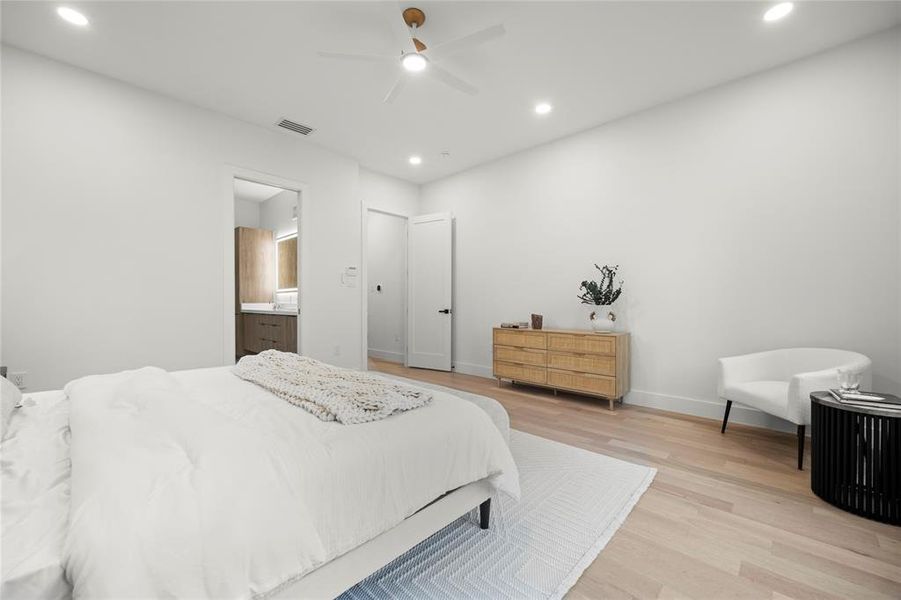 Bedroom featuring ensuite bathroom, light hardwood / wood-style flooring, and ceiling fan