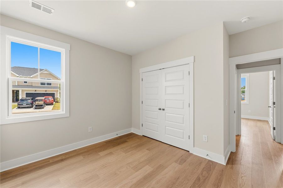 A quiet bedroom with gleaming hardwood floors offe