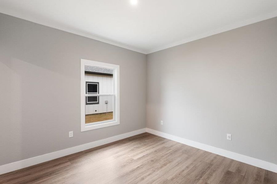 Spare room with baseboards and light wood-style floors