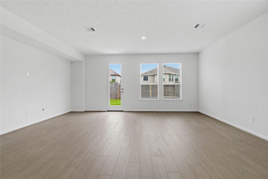 Bring family and friends together in this beautiful family room! It features high ceilings, recessed lighting, custom paint, stunning flooring, access door to the back patio, and large windows that fill the space with natural light all day long. Bring family and friends together in this beautiful family room! It features high ceilings, recessed lighting, custom paint, stunning flooring, access door to the back patio, and large windows that fill the space with natural light all day long.