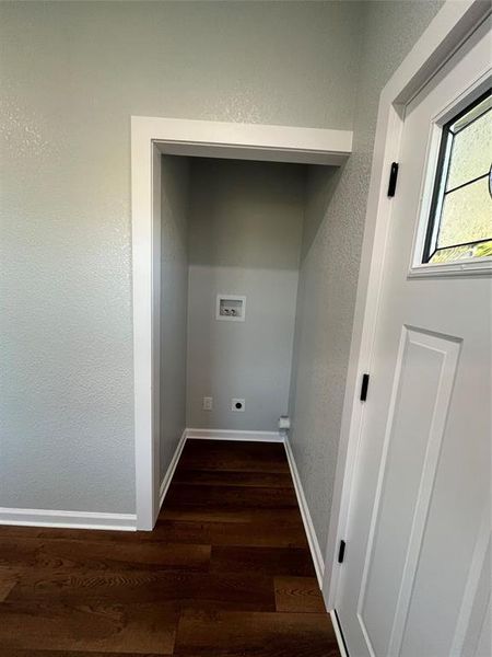 Washroom featuring dark wood-type flooring, a textured wall, washer hookup, and electric dryer hookup Washroom featuring dark wood-type flooring, a textured wall, washer hookup, and electric dryer hookup