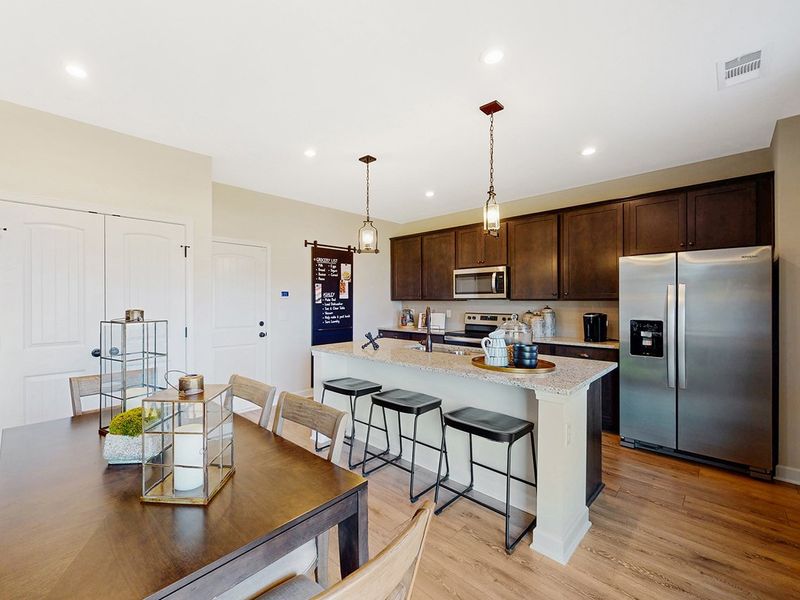 A kitchen with a table and chairs. A kitchen with a table and chairs.