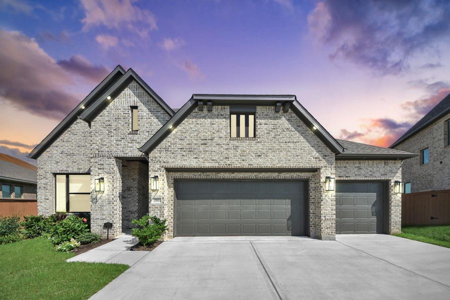Stunning brick home with a spacious three-car garage, accentuated by elegant exterior lighting and a beautifully landscaped front yard.