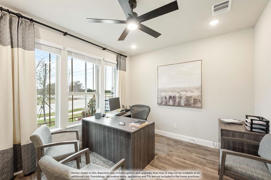 Home office with dark wood desk, ceiling fan, hardwood floors, and large windows with curtains Home office with dark wood desk, ceiling fan, hardwood floors, and large windows with curtains
