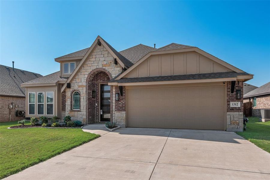 French provincial home with stone siding, roof with shingles, concrete driveway, and a garage French provincial home with stone siding, roof with shingles, concrete driveway, and a garage