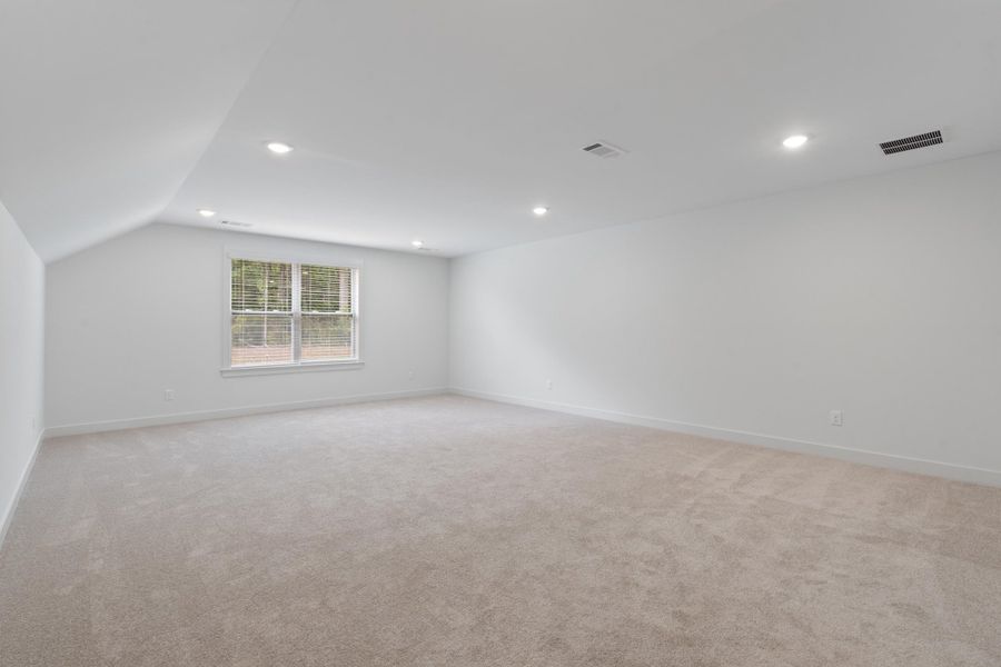 Spacious carpeted room with recessed lighting and a double window Spacious carpeted room with recessed lighting and a double window