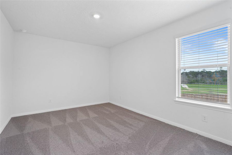 This secondary bedroom offers comfort and style with plush carpeting, neutral paint tones, recessed lighting, a large window with blinds, and a generously sized closet. This secondary bedroom offers comfort and style with plush carpeting, neutral paint tones, recessed lighting, a large window with blinds, and a generously sized closet.