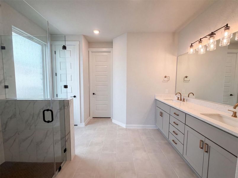 A well-appointed primary bathroom showcases dual vanities, a spacious walk-in shower, and ample natural light. A well-appointed primary bathroom showcases dual vanities, a spacious walk-in shower, and ample natural light.