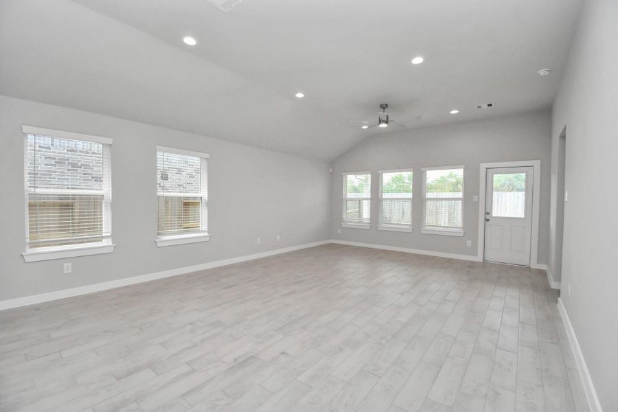 Gather the family and guests together in your lovely living room! Featuring soaring high ceilings, recessed lighting, ceiling fan, custom paint, gorgeous floors, and large windows that provide plenty of natural lighting throughout the day.