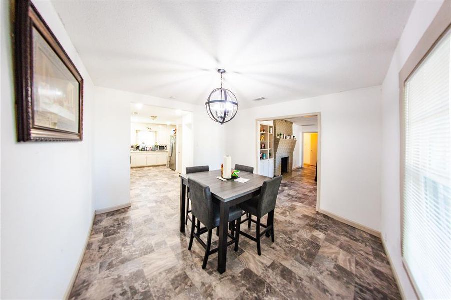 Dining room featuring a chandelier and stone finish floors