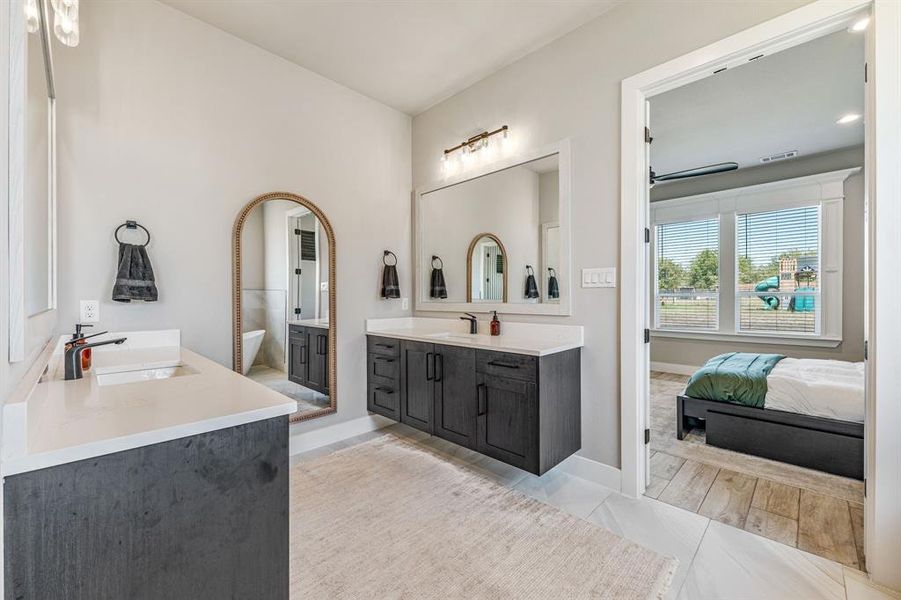Bathroom featuring two vanities and connected bathroom