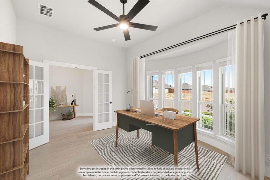 Home office with wood desk, French doors, ceiling fan, and large windows with natural light