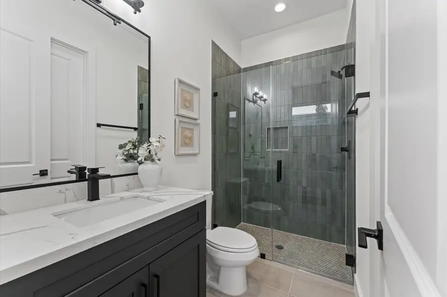 Guest suite includes a bathroom with a walk-in shower and quartz countertops.