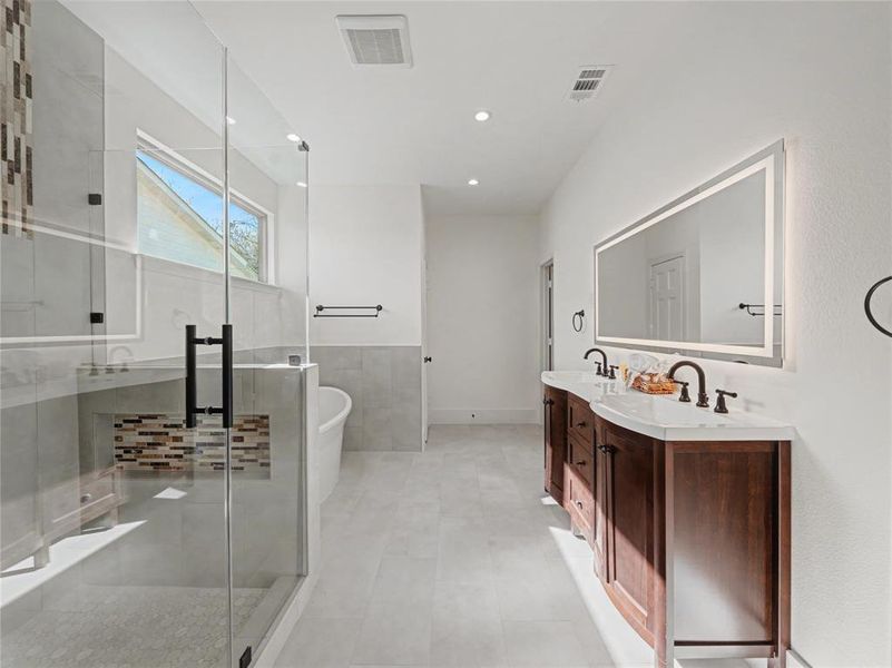 Full bathroom featuring a freestanding tub, double vanity, a shower stall, recessed lighting, and a wainscoted wall