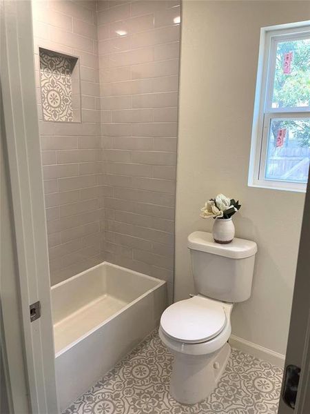 Full bathroom featuring light tile patterned floors and bathing tub / shower combination Full bathroom featuring light tile patterned floors and bathing tub / shower combination