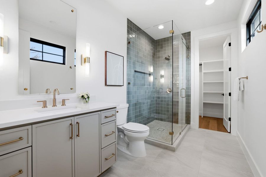 Bathroom featuring vanity, a stall shower, recessed lighting, and a spacious closet