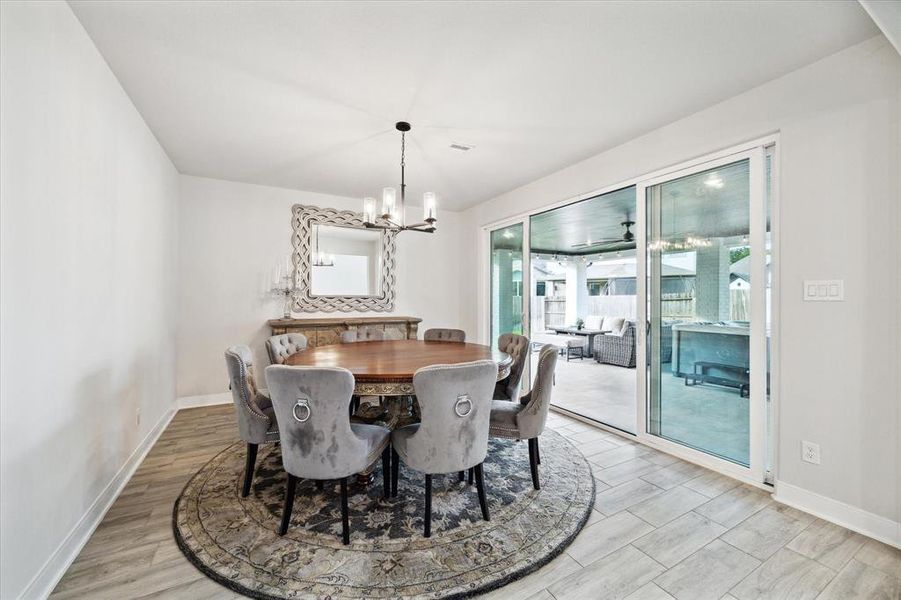 This breakfast area has sliding glass doors that lead to the covered patio and backyard retreat.